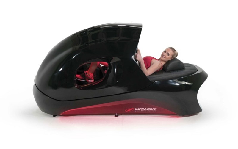 Femme utilisant un infrabike allongé avec technologie infrarouge pour un entraînement de fitness et perte de poids.